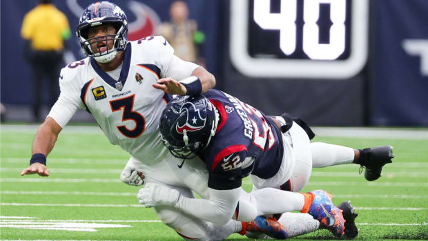 Russell Wilson is hit by Texans defense.
